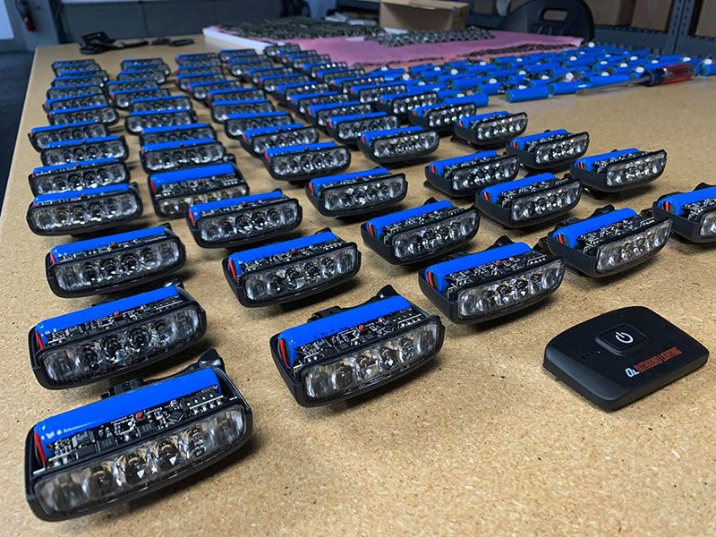 Rows of Hangover bike helmet lights on a workbench during assembly
