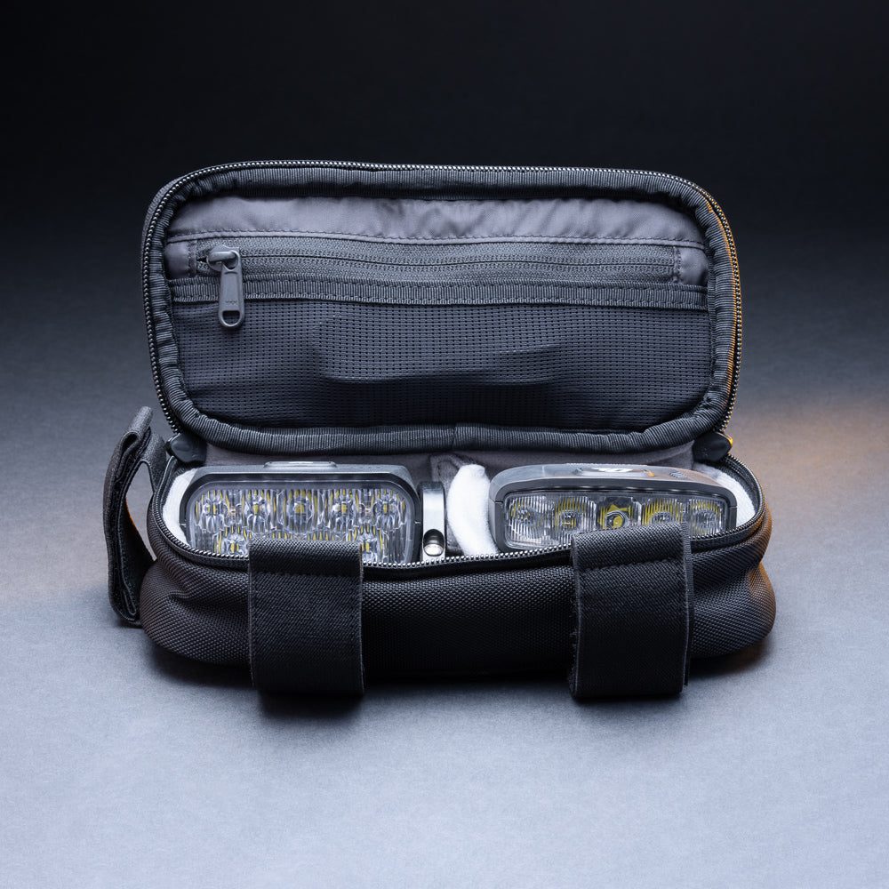 Outbound storage bag open with bike lights and accessories packed inside