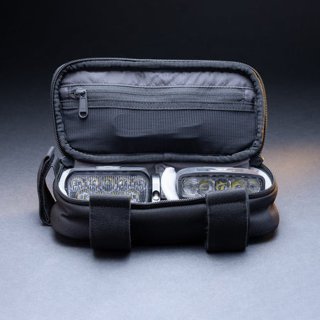 Outbound storage bag open with bike lights and accessories packed inside