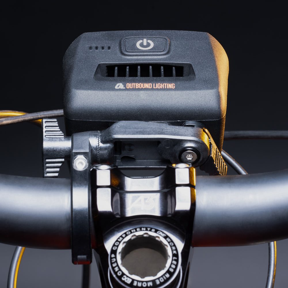 Bike light on the quick release handlebar mount clamped beside the stem