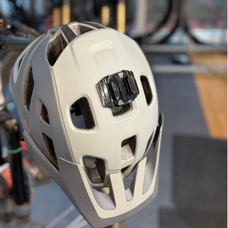 Wide helmet mount attached to the top of a tan mountain bike helmet