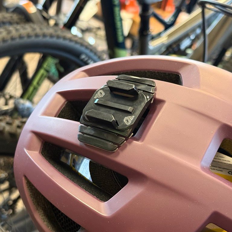 Wide helmet mount attached across the vents of a pink bike helmet